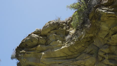 panning shot of lower cliff edge along the side of a large bolder located in santa paula punch bowl southern california