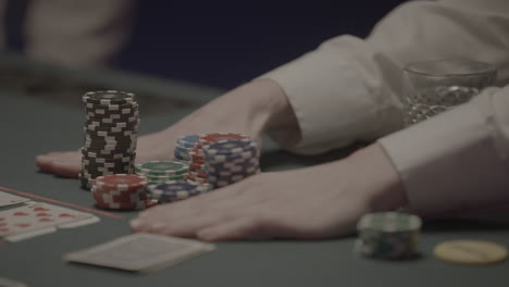 shot of a person going all in with his pokerchips pushing them to the middle of the table in slowmotion log