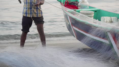 slow motion unidentified indian fisherman preparing net to boat in fort kochi, india