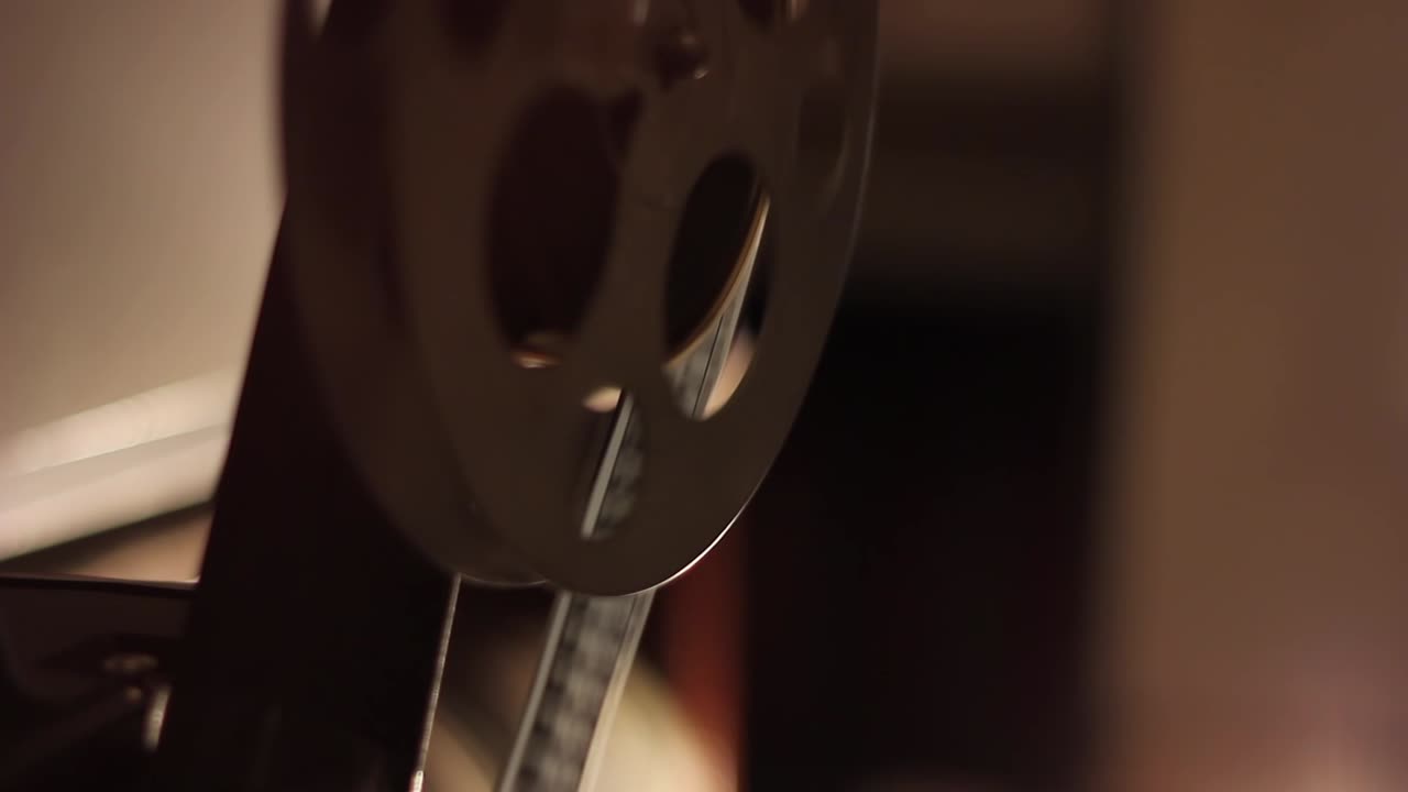 Vecchia bobina cinematografica che gira su un proiettore cinematografico d'epoca