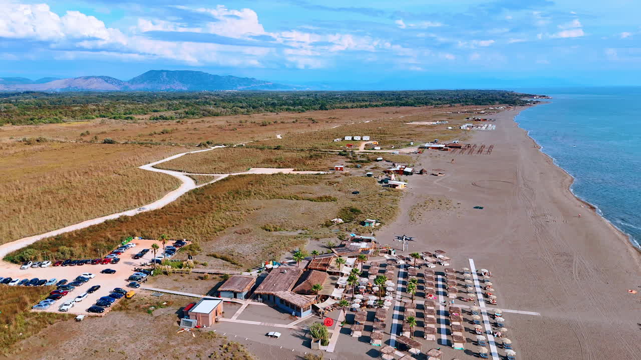 Ulcinj, Montenegro, 14 August 2025: Resort and mountains panorama. A beach complex faces distant mountains with wide open landscapes surrounding it