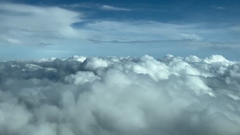 immersive pov flying ove a sea of stratus clouds as seen by the pilots of a jet from the cabin. daylight, blue sky. 4k 60fps