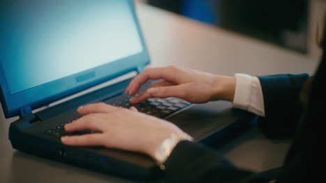 businesswoman working on laptop at workplace.