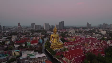 Disparo-Aéreo-De-Drones-Giratorios-Sobre-El-Gran-Buda-En-El-Templo-Wat-Paknam-Bhasicharoen-Junto-Al-Canal-Del-Río-Chao-Phraya-Durante-La-Noche