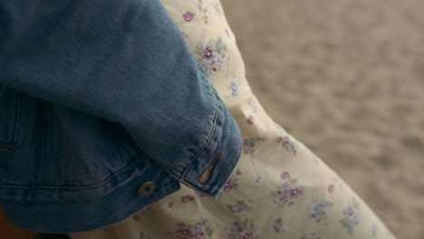 Woman-body-wearing-flowery-dress-on-sand-beach.-Girl-standing-alone-on-seashore.