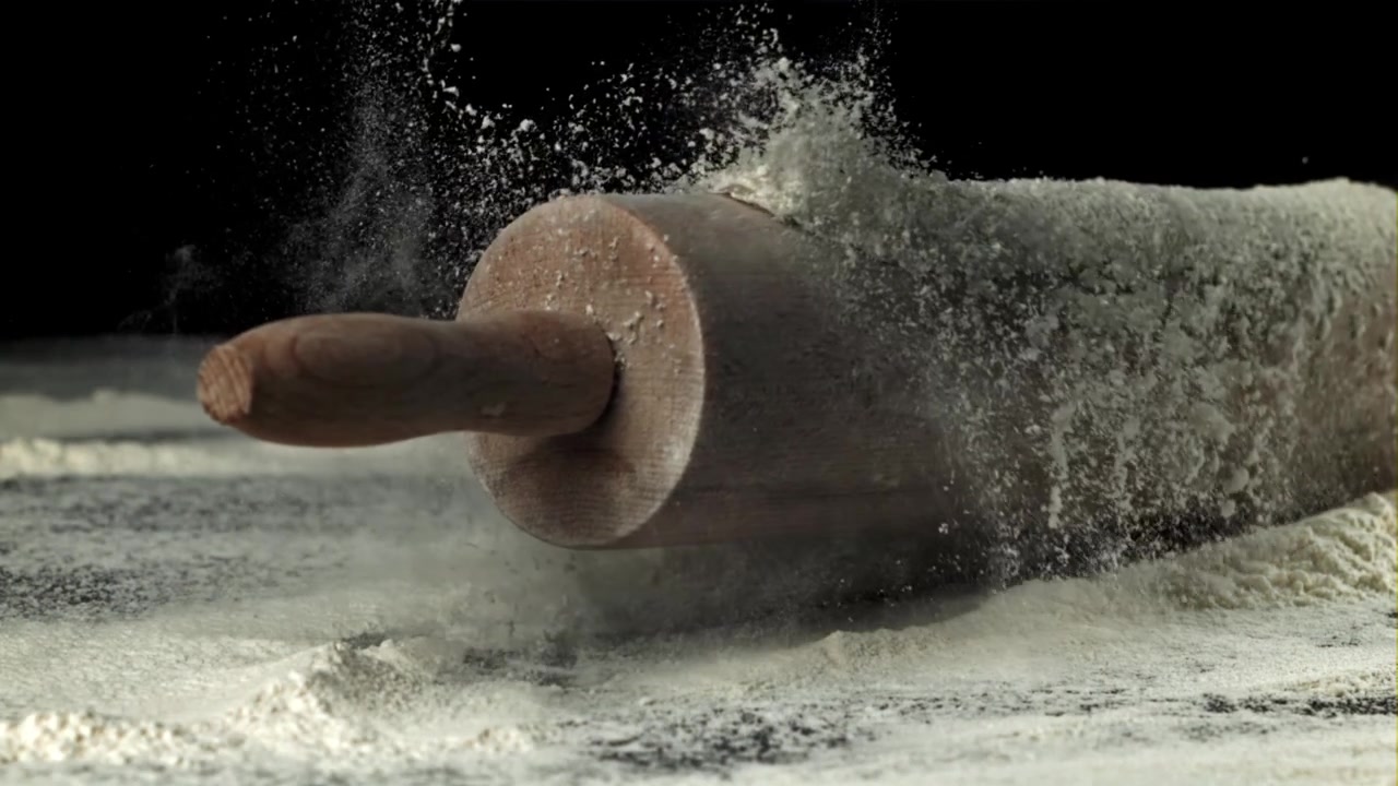 Mattarello di legno che cade sulla farina al rallentatore.