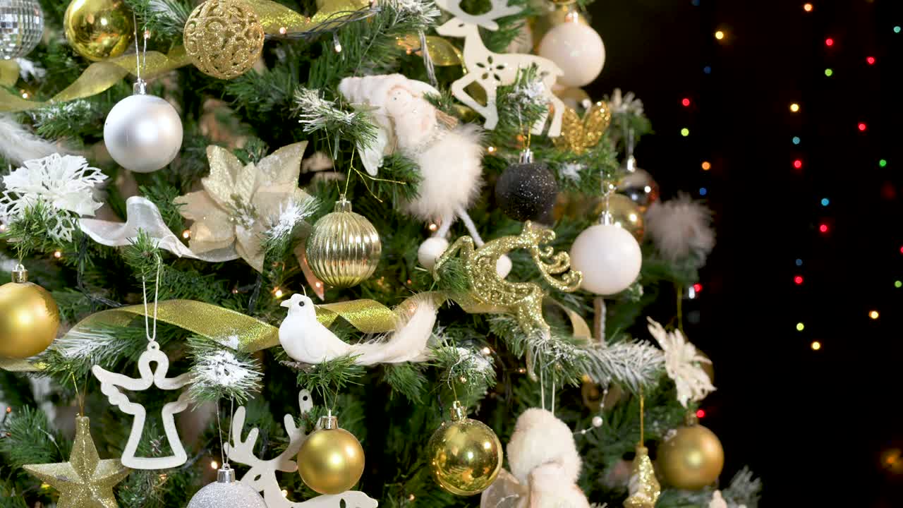 hermoso árbol de navidad decorado festivo con adornos dorados y blancos y luces parpadeantes sacudiendo el tema negro con luces parpeadas