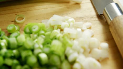 chopped scallions with knife on chopping board 4k