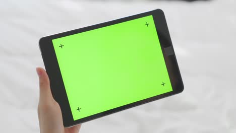 close up de mujer sosteniendo en las manos una tableta digital con pantalla verde para internet en línea, pantalla clave de croma para publicidad.