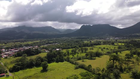 Filmische-Luftaufnahmen,-Die-Den-Vulkan-Arenal-Und-Den-Cerro-Chato-Im-Hintergrund-Umkreisen-Und-Freigeben,-Mit-Dichten-Wolken-Um-Ihre-Gipfel