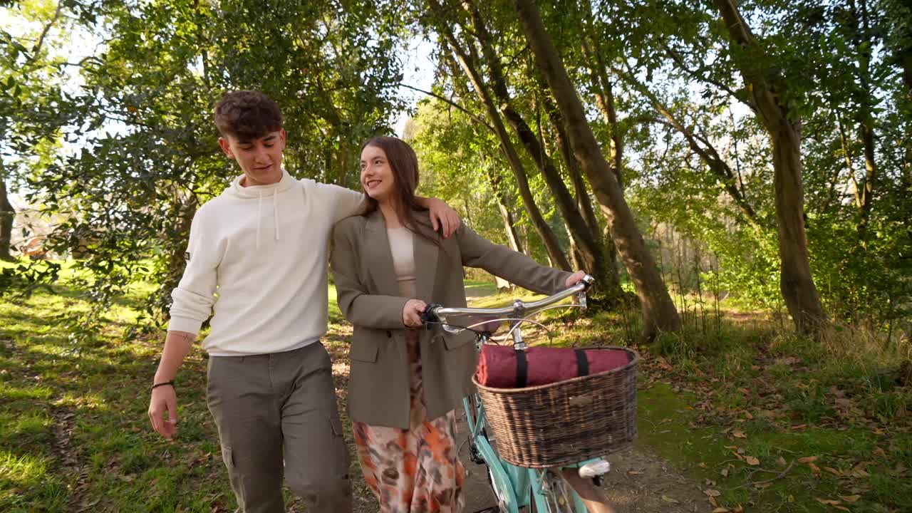 Couple walking with a bike in the forest