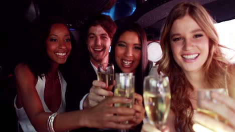 Happy-friends-drinking-champagne-in-limousine