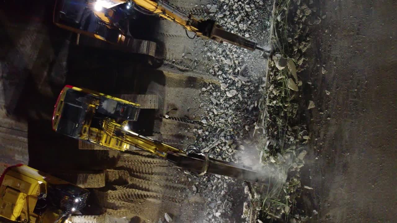 медленный воздушный снимок нескольких экскаваторов, медленно разрушающих мост в канаде.