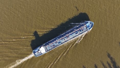 tanker sails gracefully across river as the hull slices through water