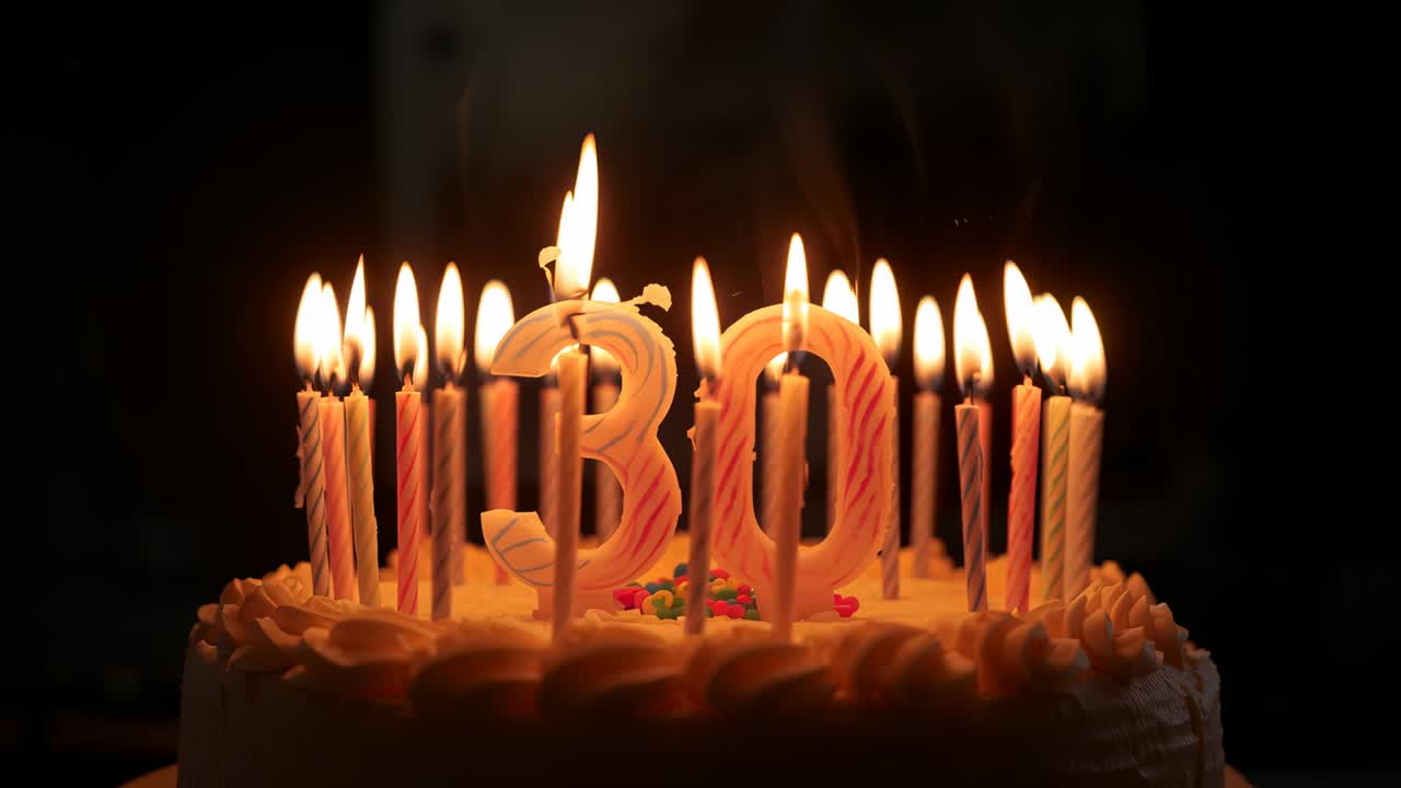 Dancing flames, initially lit, moving on frosted birthday cake at dim table, with numeral 30