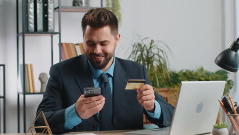 hombre de negocios haciendo compras en línea pago compras con tarjeta de crédito bancaria y portátil en la oficina