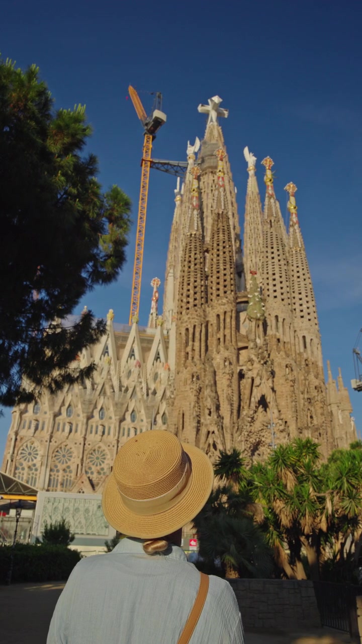 Mulher de chapéu de palha admirando a Sagrada Família em Barcelona