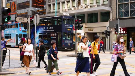 people crossing a bustling intersection in hong kong