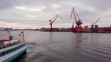 vuelo aéreo suave de drones hacia un pequeño ferry de pasajeros atracado en la zona del puerto de gotemburgo, suecia