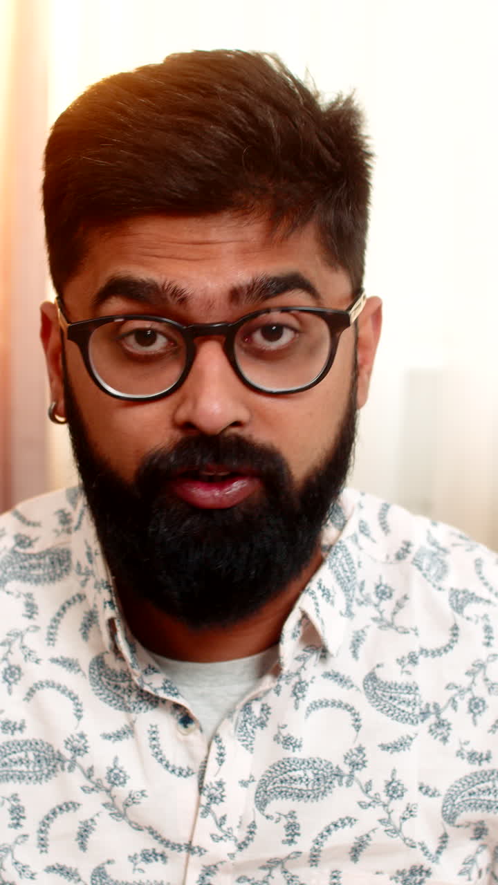 Indian man taking off glasses and rubbing tired eyes after long remote computer work sitting at home