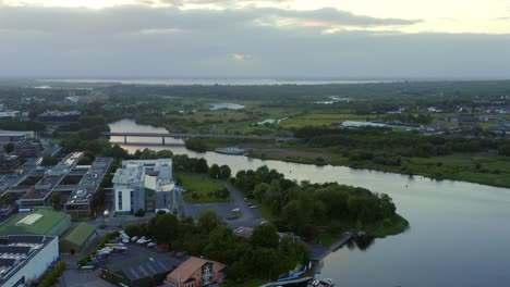 Drone-pans-above-River-Corrib-looking-up-to-lake-from-Galway-at-sunset