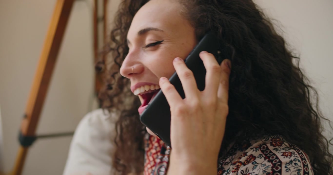 Jovem Mulher Conversando Animadamente ao Telefone em Casa.