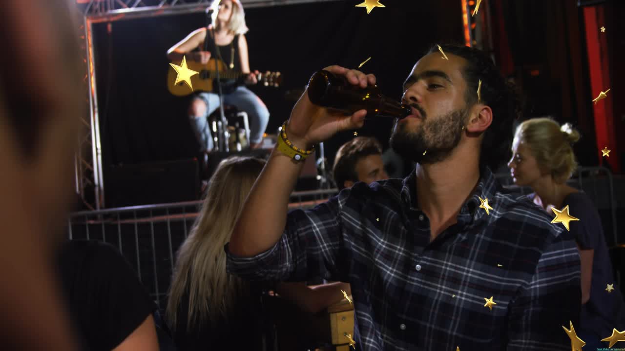 Guitarist strumming bar stage starting set, man sipping beer while socializing, gold stars drifting