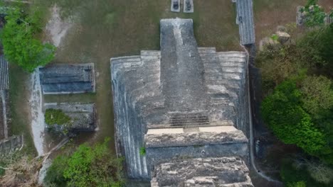 Luftaufnahmen-Zeigen-Den-Majestätischen-Tikal-Tempel,-Umgeben-Von-üppigem-Grün,-Und-Zeigen-Die-Pracht-Der-Alten-Maya-Architektur-Aus-Der-Vogelperspektive