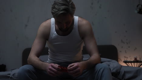 man sitting on bed at night