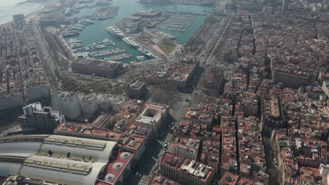 High-angle-view-of-urban-borough.-Wide-multilane-street-leading-along-port-with-moored-boats.-Barcelona,-Spain