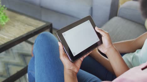 madre y hija afroamericanas usando una tableta con espacio de copia en la pantalla