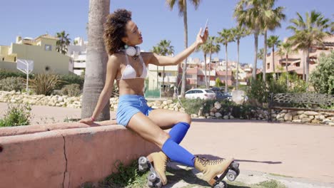 mujer alegre con top de traje de baño y pantalones cortos azules