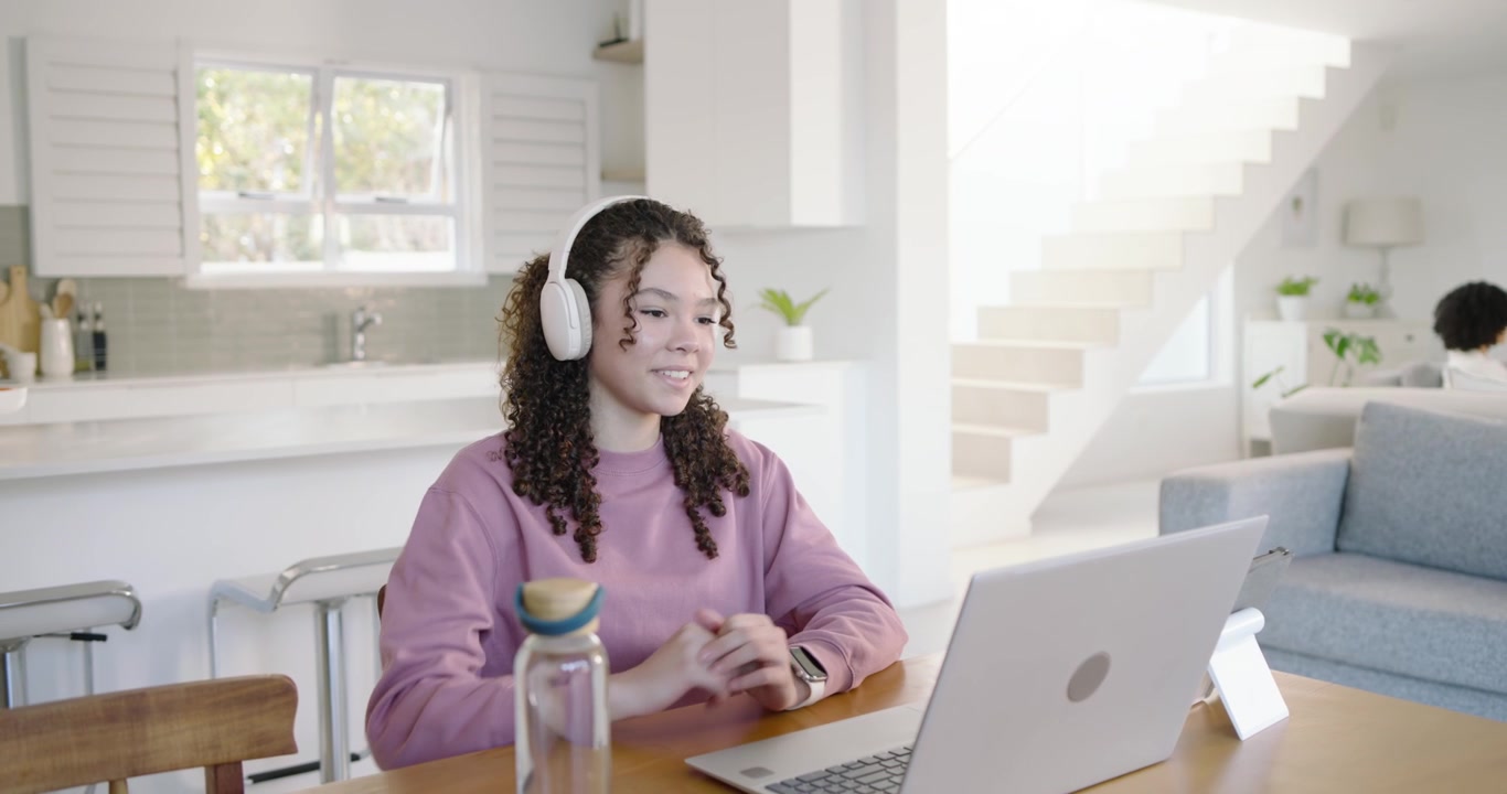 African American youth female joining online class speaking typing on laptop at wooden table