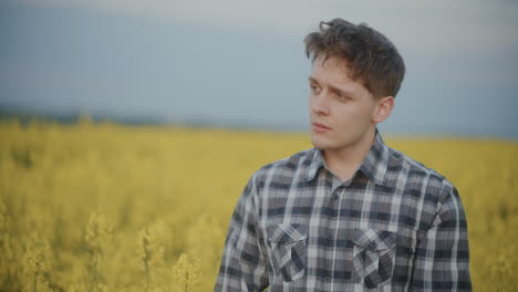 contemplative farmer against yellow flowers in farm