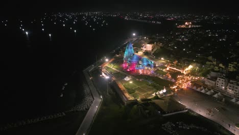 aerial view of illuminated temple at night on the coast