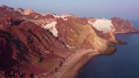 Küstenhorizont-Berg-In-Der-Nähe-Des-Strandes-Und-Blaues-Meer-In-Der-Nähe-Des-Windes,-Polierte-Erosionsgebirgsfelsen-Am-Goldenen-Sandstrand-Im-Iran,-Campingplatz-Auf-Der-Insel-Hormuz,-Das-Surf-Wassersport-Abenteuer