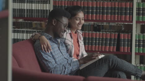 chica guapa y chico negro guapo estudiando en la biblioteca 1