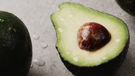 Micro-video-of-close-up-of-avocados-with-copy-space-on-grey-background