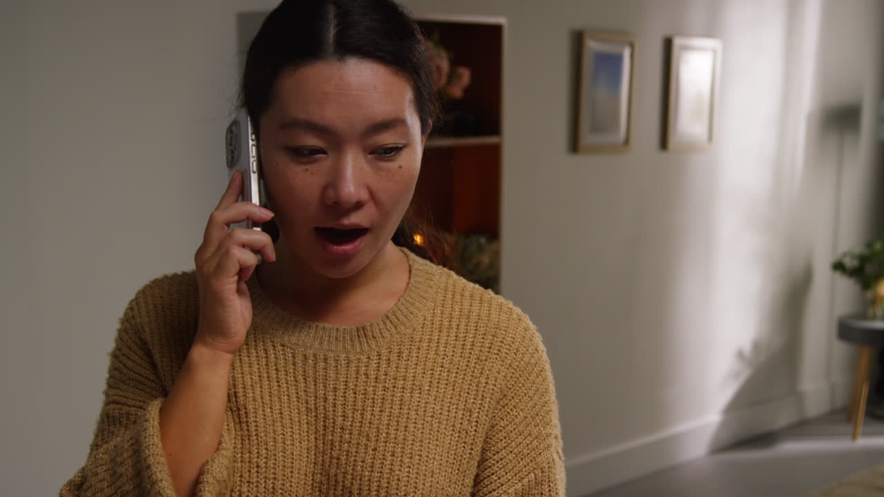 집에서 휴대 전화로 이야기하는 라운지에서 미소 짓는 여성의 클로즈업 1