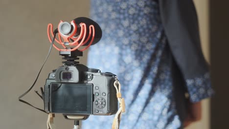 mujer de pie frente a la cámara y grabando video