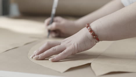 woman marking pattern for sewing