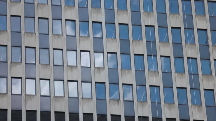 Primo piano di nuvole che si riflettono sulle finestre di un edificio per uffici.