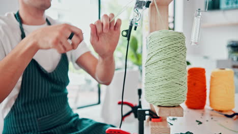 man working with yarn and sewing machine