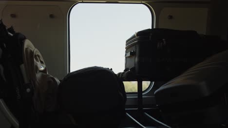 several suitcases on the window seat of a train as it moves forward