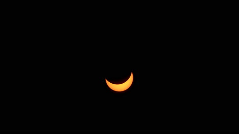 partial phase of eclipse rises into the sky in time-lapsed motion