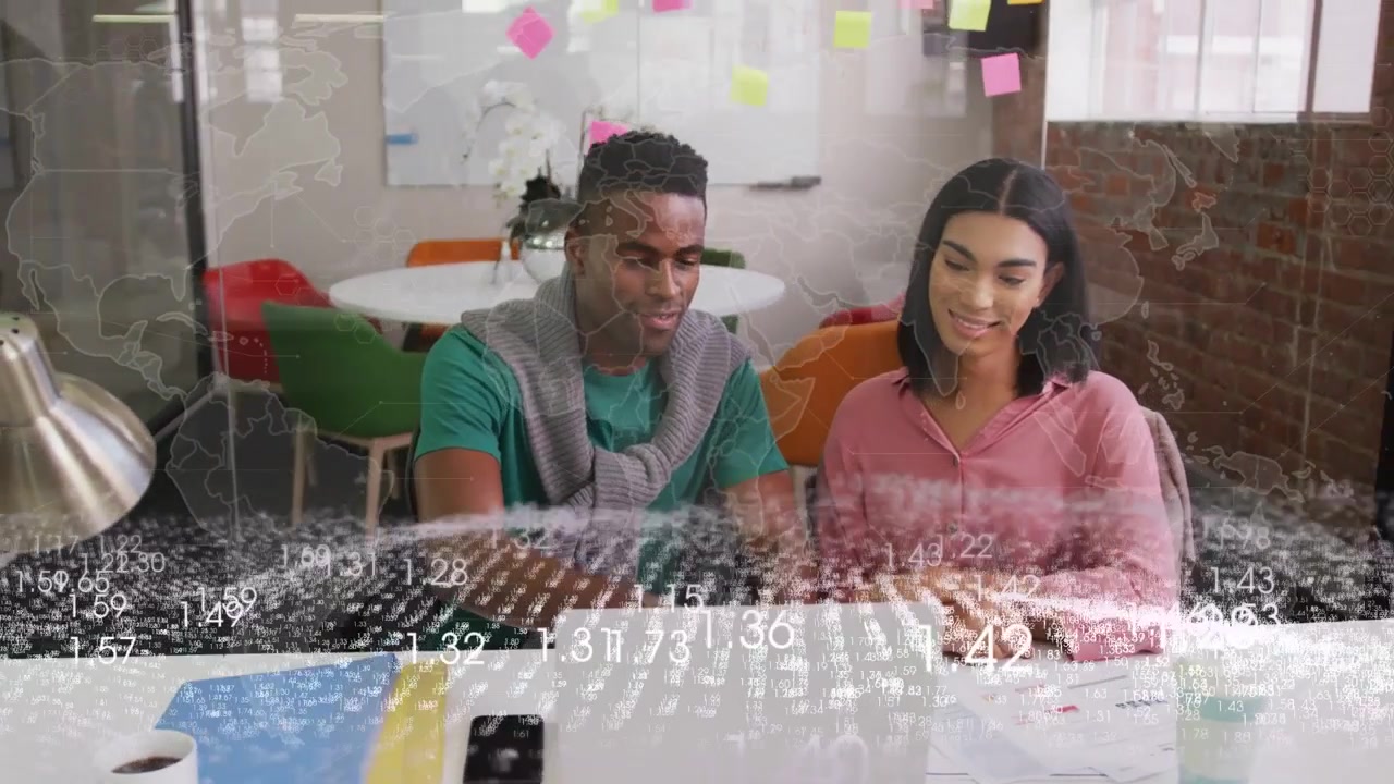 Man typing and pointing at laptop while woman leaning in, animated map highlighting business charts