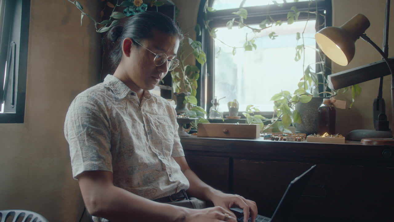 Asian Man Working on Laptop in Antiques Shop