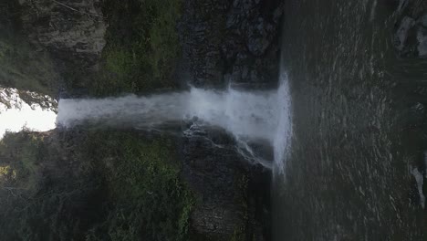 cañón de la selva sombreado, acercándose a la cascada salpicando en hawai