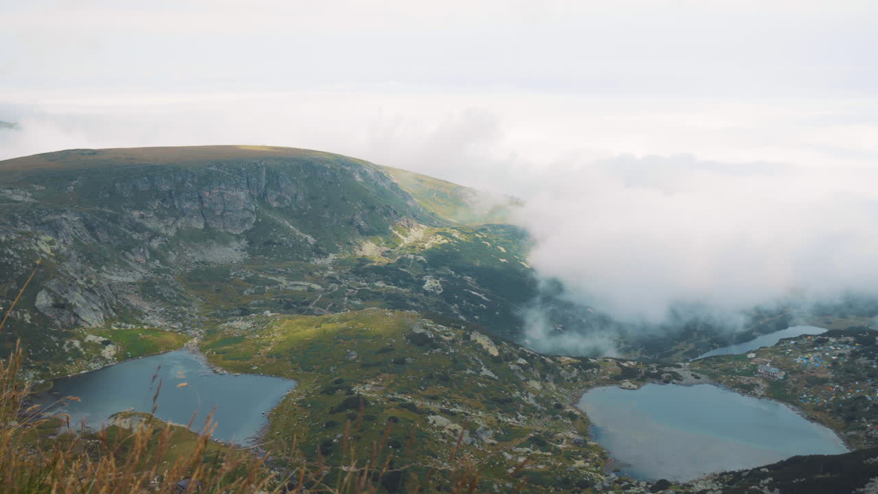 Panoramic view from the Haramiyata peak of the Rila lakes in Bulgaria. You can see the camp of the White Brotherhood and the lakes shamrock and twin. Low clouds covered the mountain