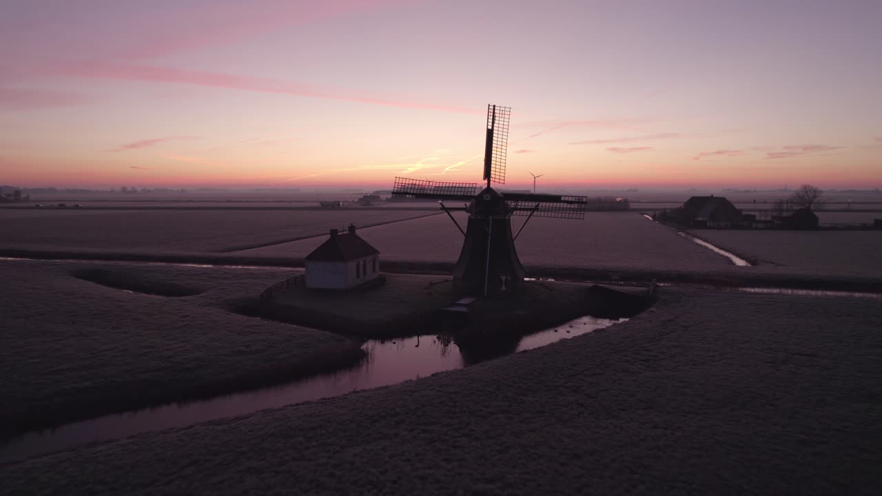 추운 아침 에 바부르스터몰렌 풍차 근처 에서 날아다니는 항공기